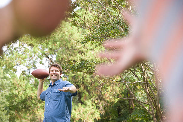 istock Man Tossing Football 520859999