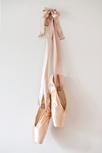 Pair of ballet slippers hanging on the wall