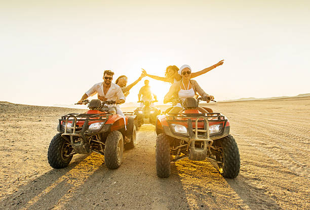 istock Young people driving quad bikes at sunset. 520863743