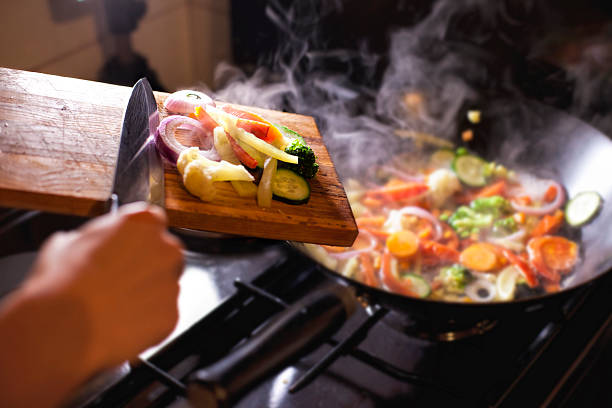 istock Putting chopped vegetables in the pan 520864079