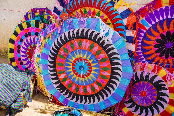 Colorful handmade kites for sale on the street. Locals display huge circular kites called barriletes & fly smaller ones each year in the cemetery on All Saints' Day to honor spirits of the dead.