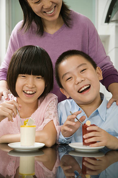 istock Boy and girl having breakfast with their mother standing behind 520866429