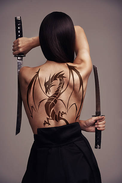 the girl with the dragon tattoo - tattoo women back rear view - fotografias e filmes do acervo