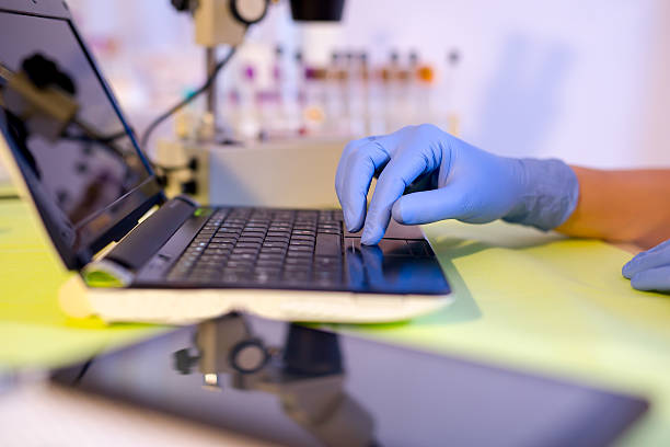 wissenschaftler arbeiten im labor auf einen laptop - laboratory microscope pathologist scientist stock-fotos und bilder