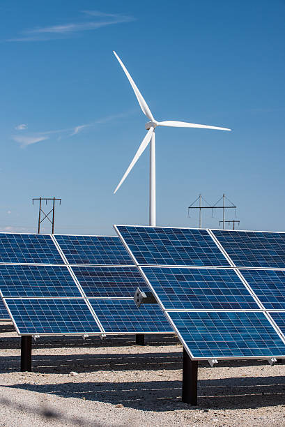 istock Solar panels and wind turbines in sunny desert 520876512