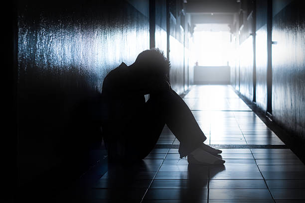 istock Sad or hopeless man sit in dark location. 520878476