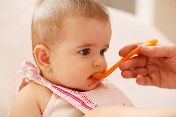 istock Baby girl eating. 520878502