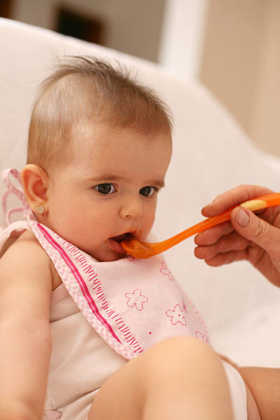 istock Baby girl eat. 520878606
