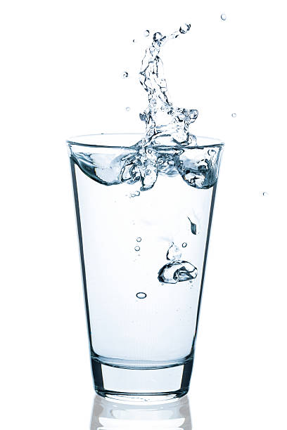 water glass with splashing water and drops - glas water stockfoto's en -beelden