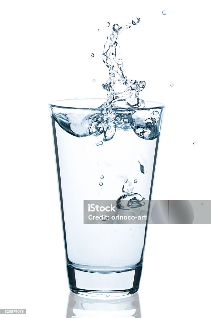 Water glass with splashing water and drops Water glass with splashing water and drops isolated on a white background Drinking Glass Stock Photo