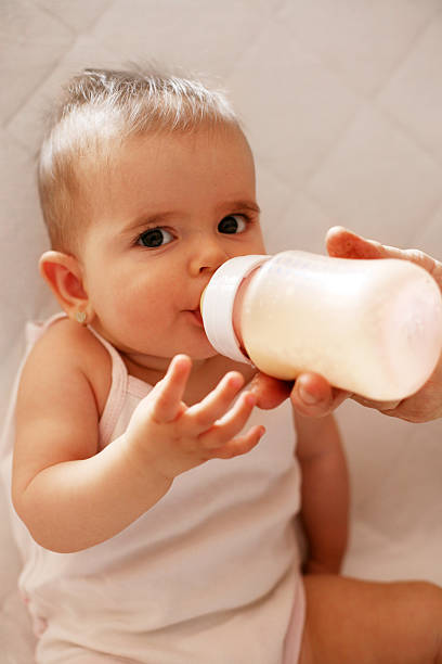 istock Baby girl drinking milk from her bottle. 520879238