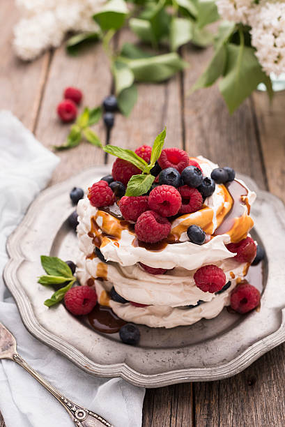 Caramel Pavlova Cake Caramel Pavlova Cake with fresh berries pavlova stock pictures, royalty-free photos & images