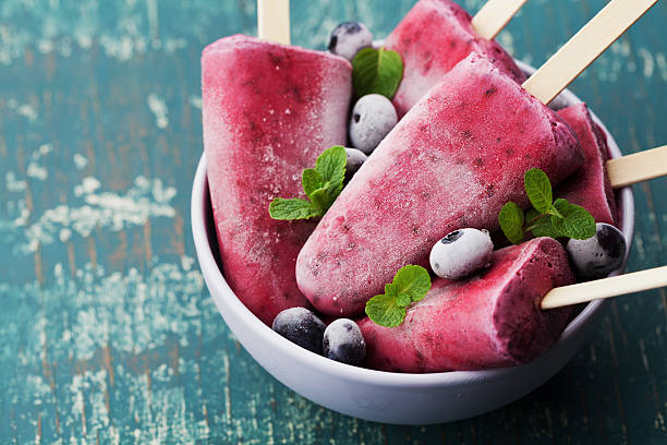istock Homemade blueberry ice cream or popsicles on teal rustic table 520879596