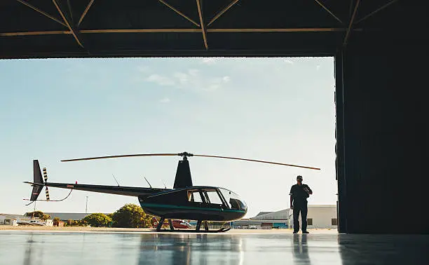 Photo of Pilot with a helicopter in airplane hangar