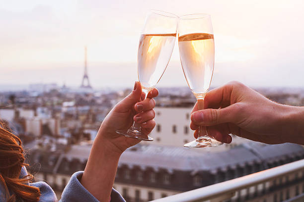 couple drinking champagne in Paris two glasses of champagne or wine, couple in Paris, romantic celebration of engagement or anniversary couple drinking stock pictures, royalty-free photos & images