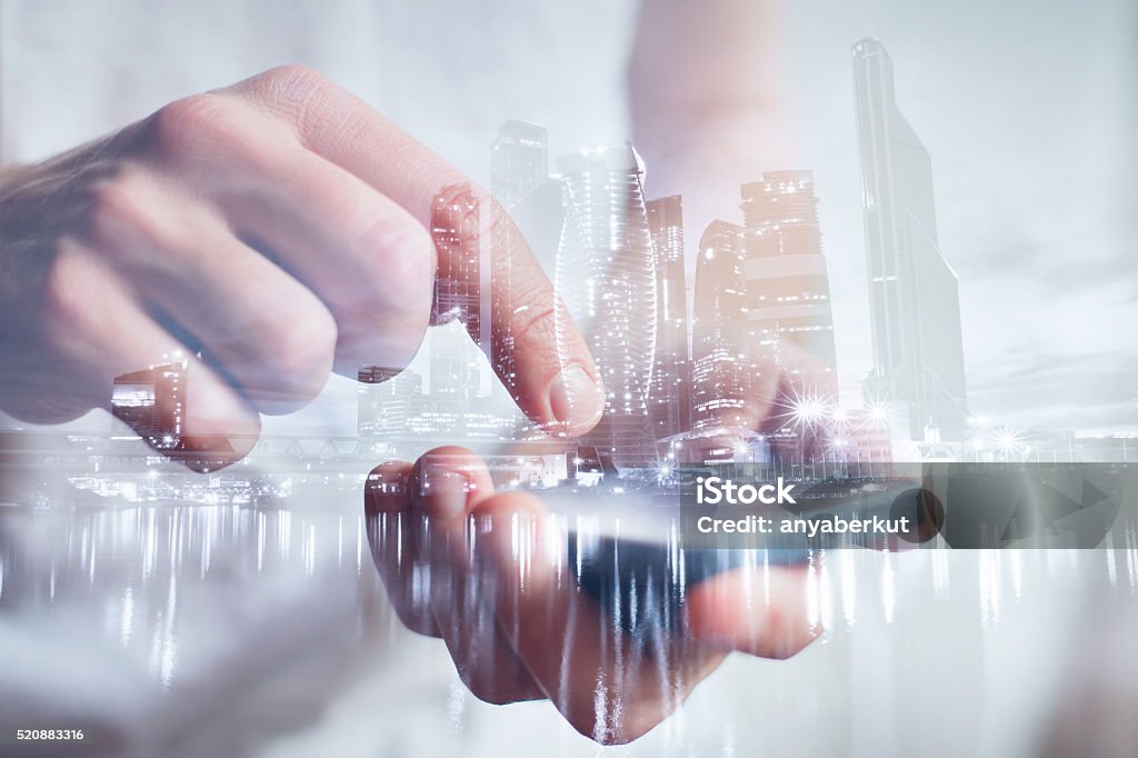 hands with mobile, double exposure man hands touching smartphone, closeup, double exposure with modern city skyline City Stock Photo