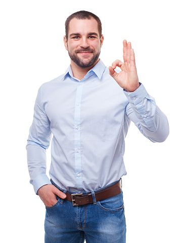 Young man in blue shirt makes gesture ok. Isolated on white background