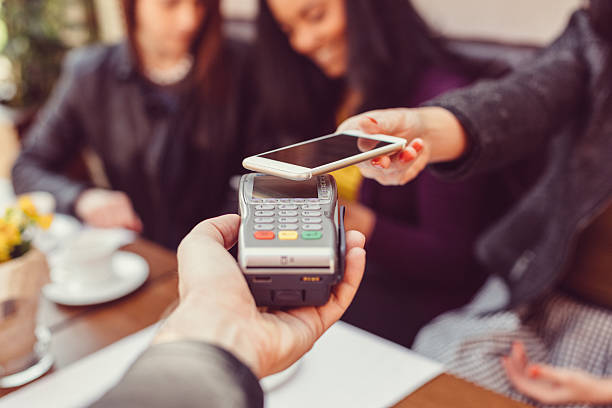 mujer haciendo pago sin contacto con teléfono inteligente - pago por movil fotografías e imágenes de stock