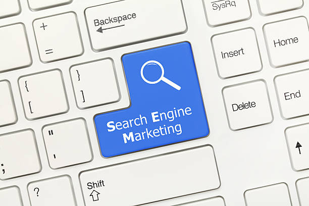 Close-up view on white conceptual keyboard - Search Engine Marketing (blue key with magnifying glass symbol)