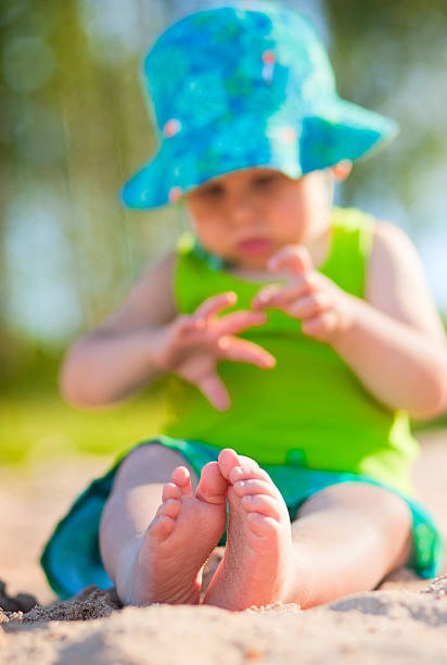 istock Cute baby sitting on the sand 520885472