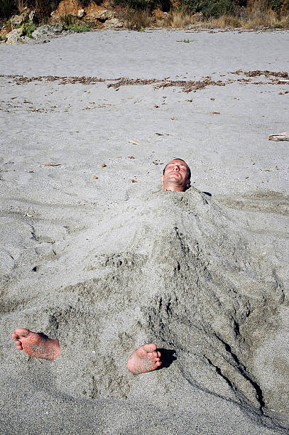 istock Man covered by sand on the beach 520885541