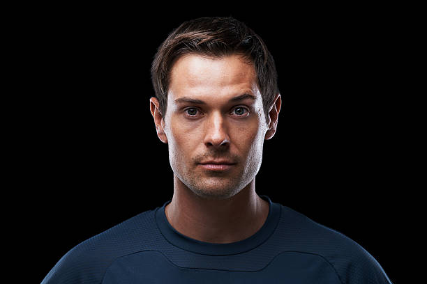 Dedicated to staying fit Studio portrait of a determined young man in sports clothing standing against a black background no emotion stock pictures, royalty-free photos & images