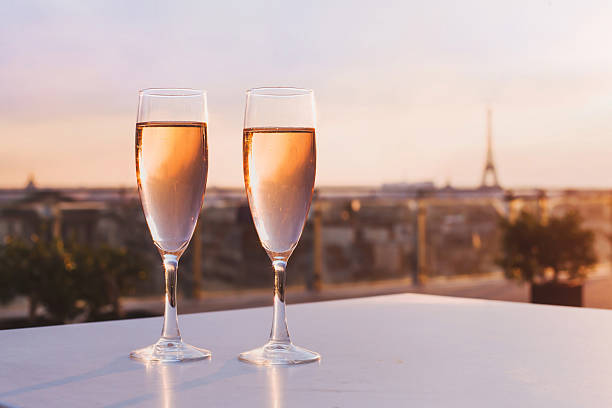 two glasses of champagne on Eiffel tower background two glasses of champagne at rooftop restaurant with view of Eiffel Tower and Paris skyline, luxury romantic dinner for couple nice france restaurant stock pictures, royalty-free photos & images