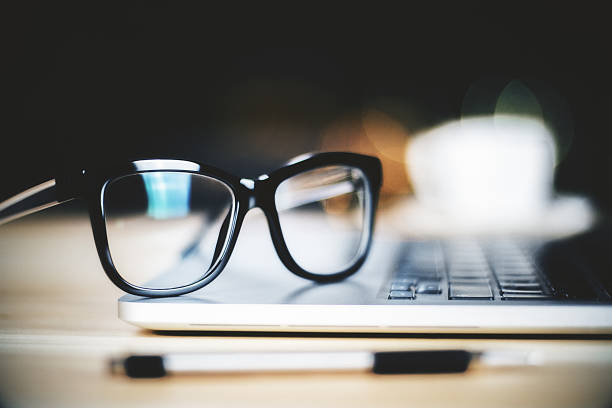 Glasses on laptop with pen, close up Glasses on laptop with pen, close up spectacles stock pictures, royalty-free photos & images