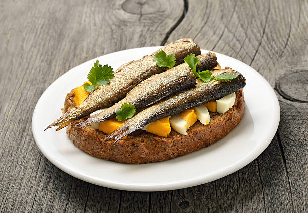 istock Sandwich with sprats and egg on wooden table 520886610