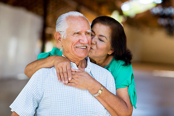 senior letra mulher experimentando e beijar a bochecha de idoso - latin american and hispanic ethnicity senior adult mature adult couple imagens e fotografias de stock