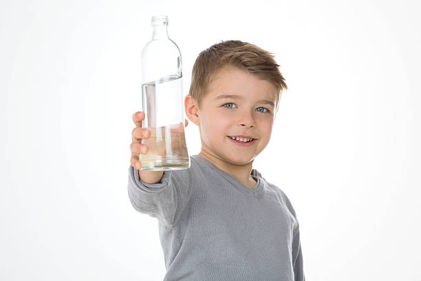 potrait of child kid shows a bottle of water little boys blue eyes blond hair one person stock pictures, royalty-free photos & images