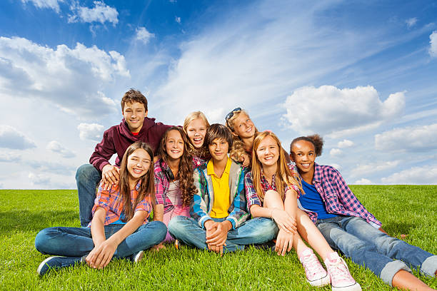 istock Happy international kids sit close on grass 520887939