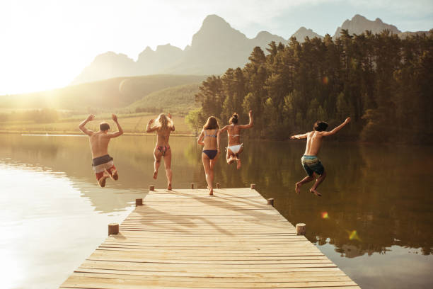 istock Group of young people jumping into the water 520888212