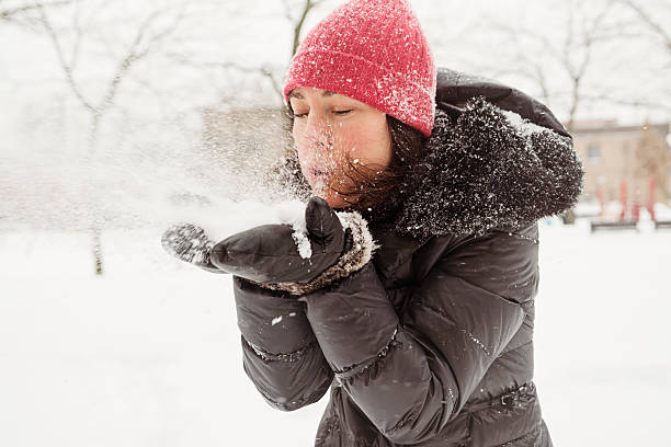 istock Real woman blowing out some fresh fallen snow. 520889551