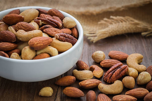 istock Mixed nuts on wooden table and bowl 520889996