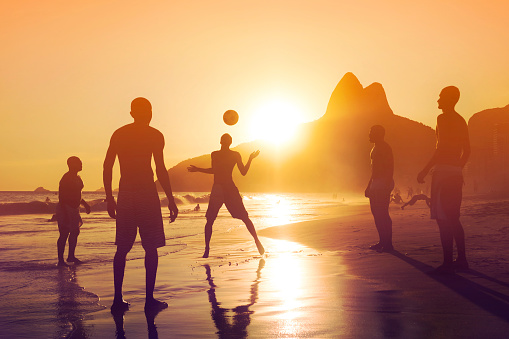 Rio de Janeiro, Brazil - February 05, 2016: Silhouette of unidentified locals playing ball game at sunset in Ipanema beach, Rio de Janeiro, Brazil.