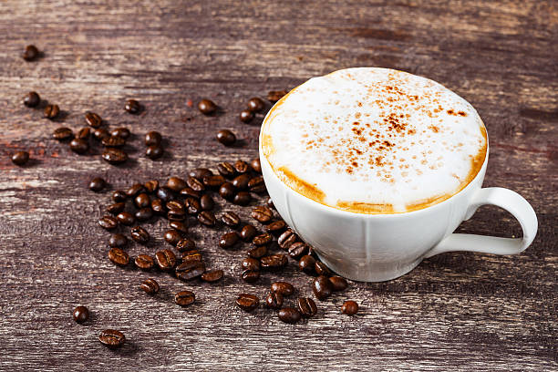 istock Cup of coffee and roasted bean on old wooden table 520912231
