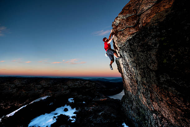 athlète escalade au coucher du soleil - mountain climbing rock climbing motivation awe photos et images de collection