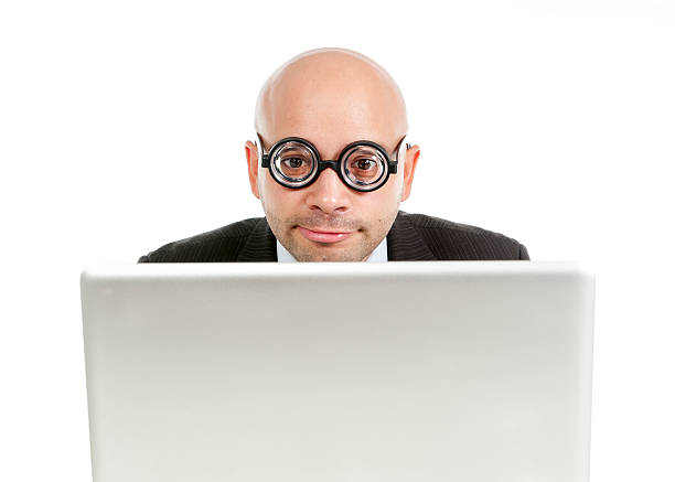 istock geek and freak bald head businessman with computer laptop 520916195