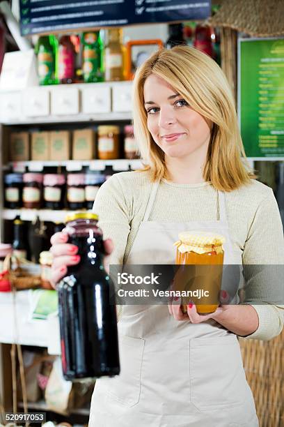 Young Woman Holding Homemade Jam And Juice At Shop Stock Photo - Download Image Now - Mature Women, Pantry, Shopping