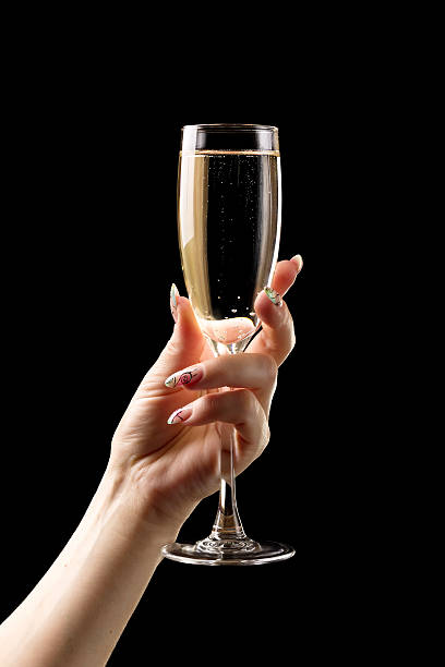 女性手にはシャンパングラスにブラックのバックグラウンド。 - champagne celebration glass black ストックフォトと画像