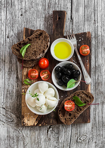 istock Mediterranean snack - mozzarella, olives, rye ciabatta bread, cherry tomatoes 520937542