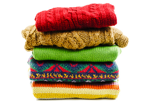 Stack of various sweaters. Winter style. Isolated on white background