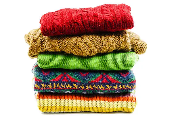 Stack of various sweaters. Winter style. Isolated on white background