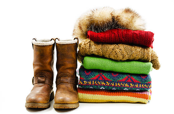 bottes d'hiver, bonnet et une pile de plusieurs pulls. hiver style - vêtement chaud photos et images de collection