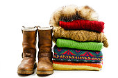 Winter boots, cap and stack of various sweaters. Winter style