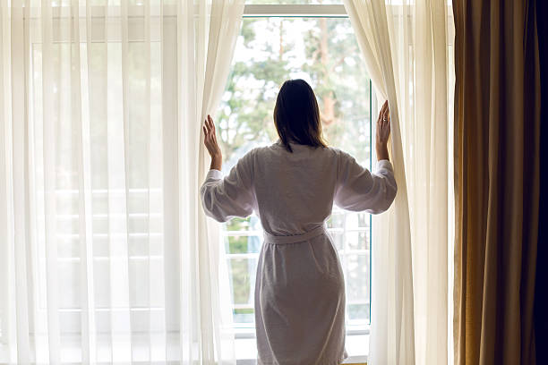 istock girl standing at the window 520940292