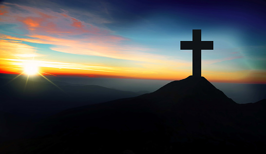 Christianity concept with christian cross silhouette on the hill on sunset