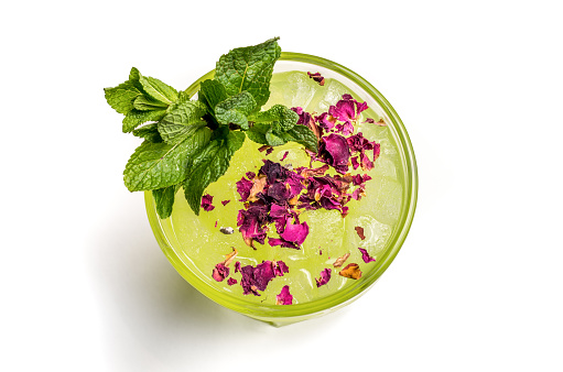 superior view of a green cocktail with mint and flower decored