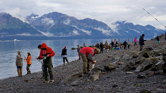 Seward, Alaska, United States - September 10, 2014: Many people fishing salmon on coast in Resurrection Bay in Seward, Alaska